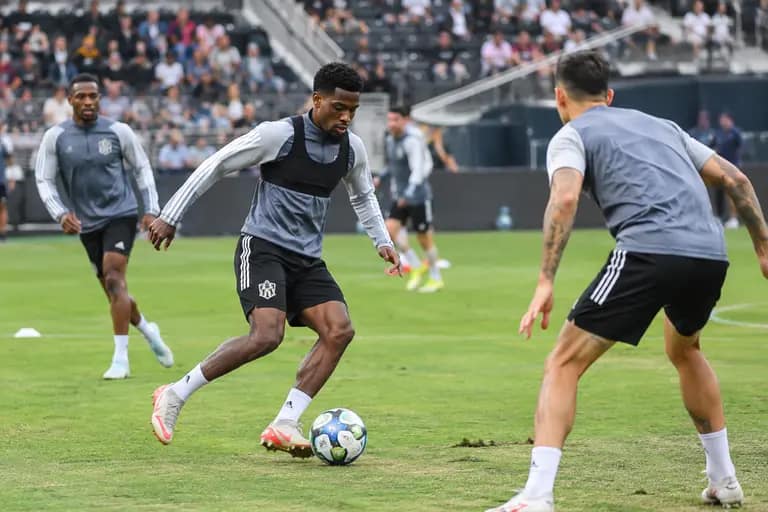 Soccer players warming up inside a modern city stadium before a match